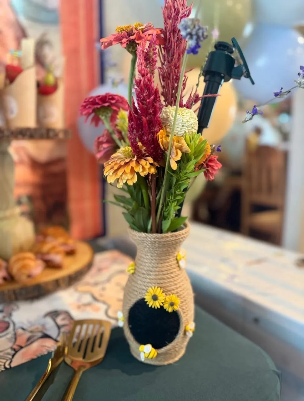 Rope-wrapped vase of colorful wildflowers on a styled table