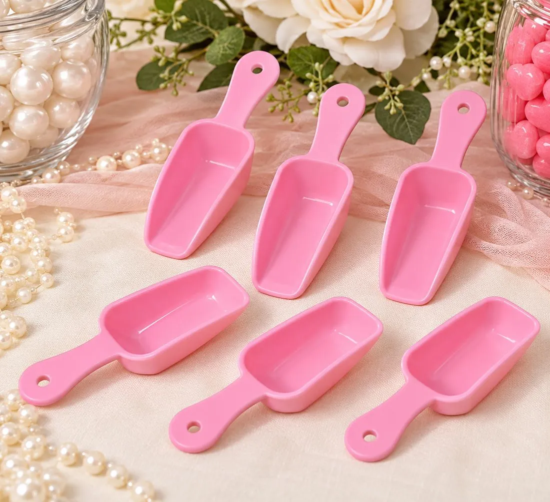 Six pink candy scoops beside jars of pearls and pink candy