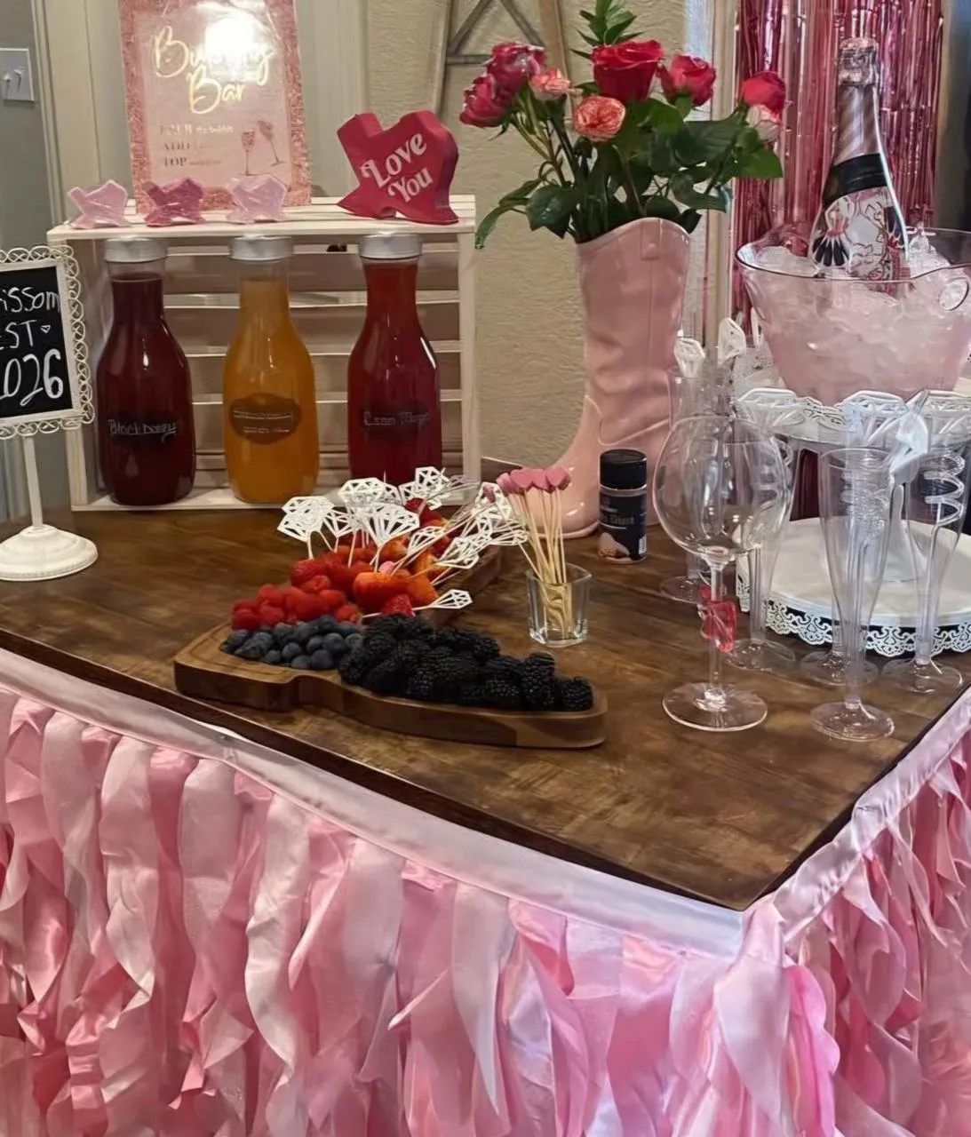 Drink and dessert bar with pink ruffled skirting and fresh roses